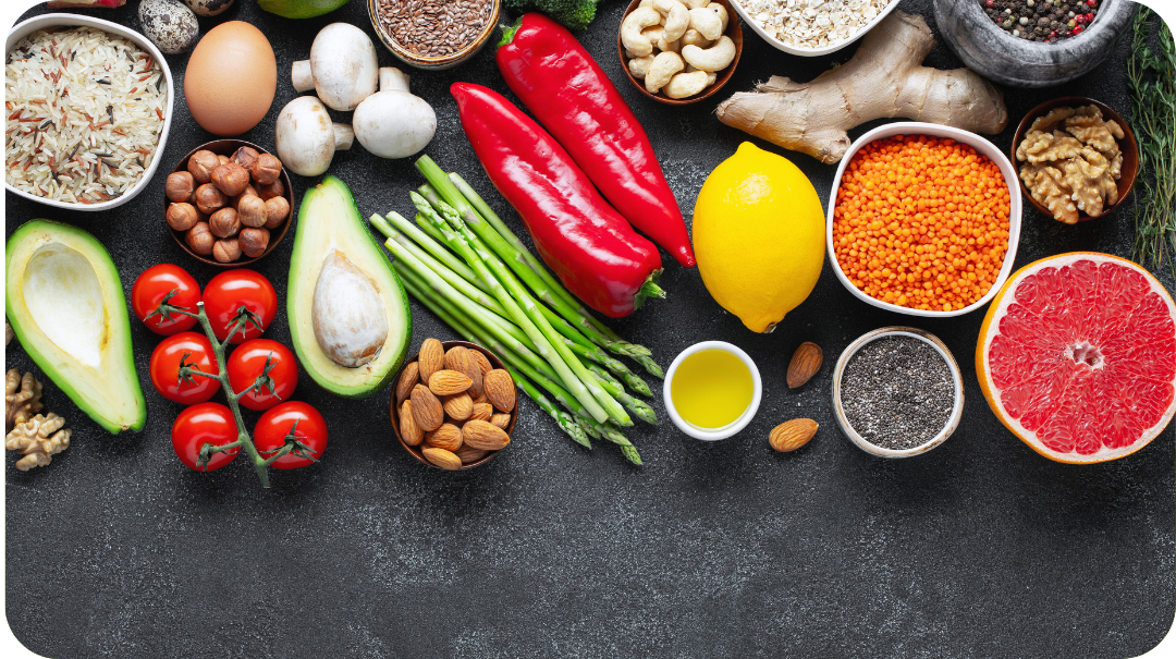 Various fruits, vegetables and nuts displayed neatly on a stone surface 